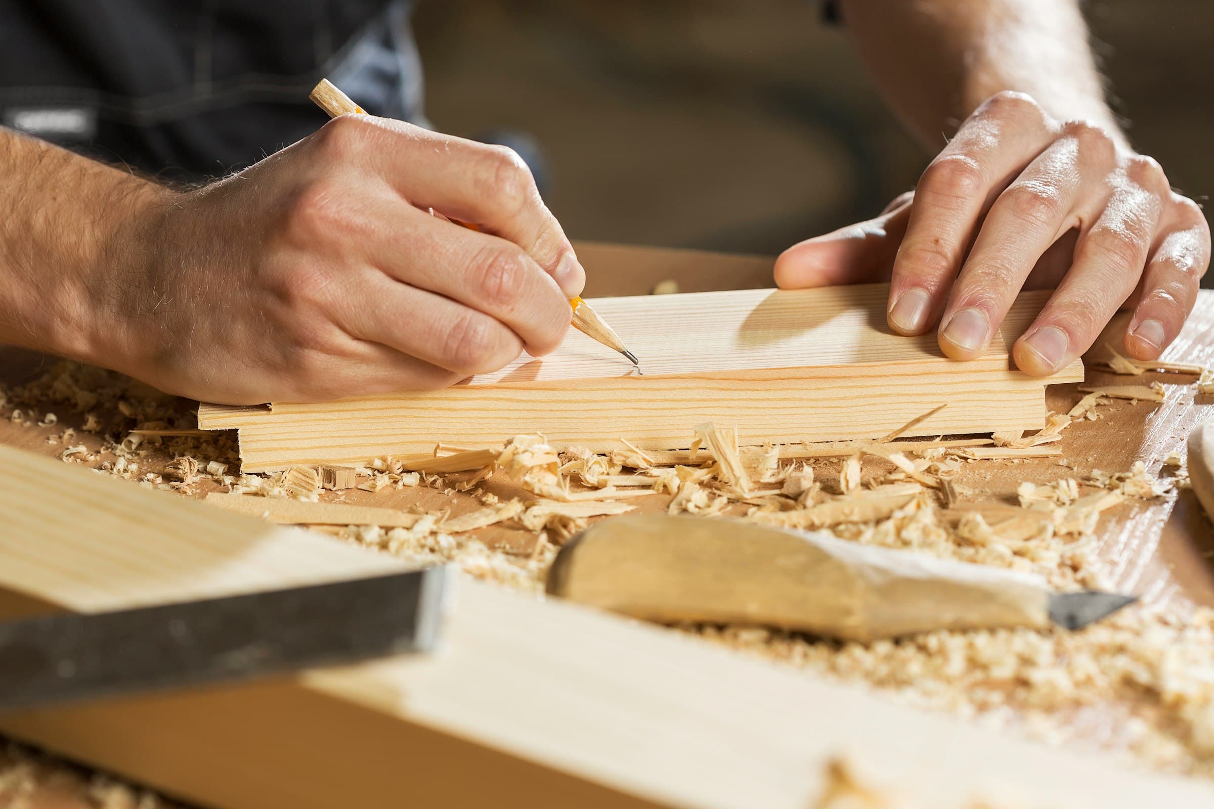 Schrijnwerker tekent een maat af op een plank